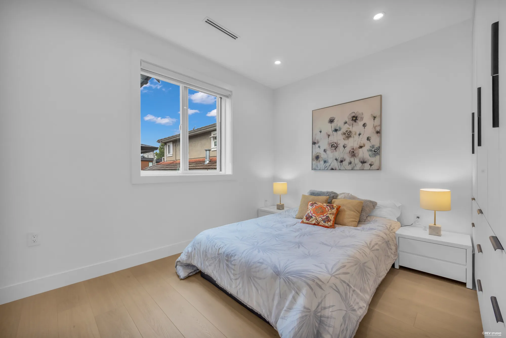 Third bedroom with a bed under framed art and a window to one side