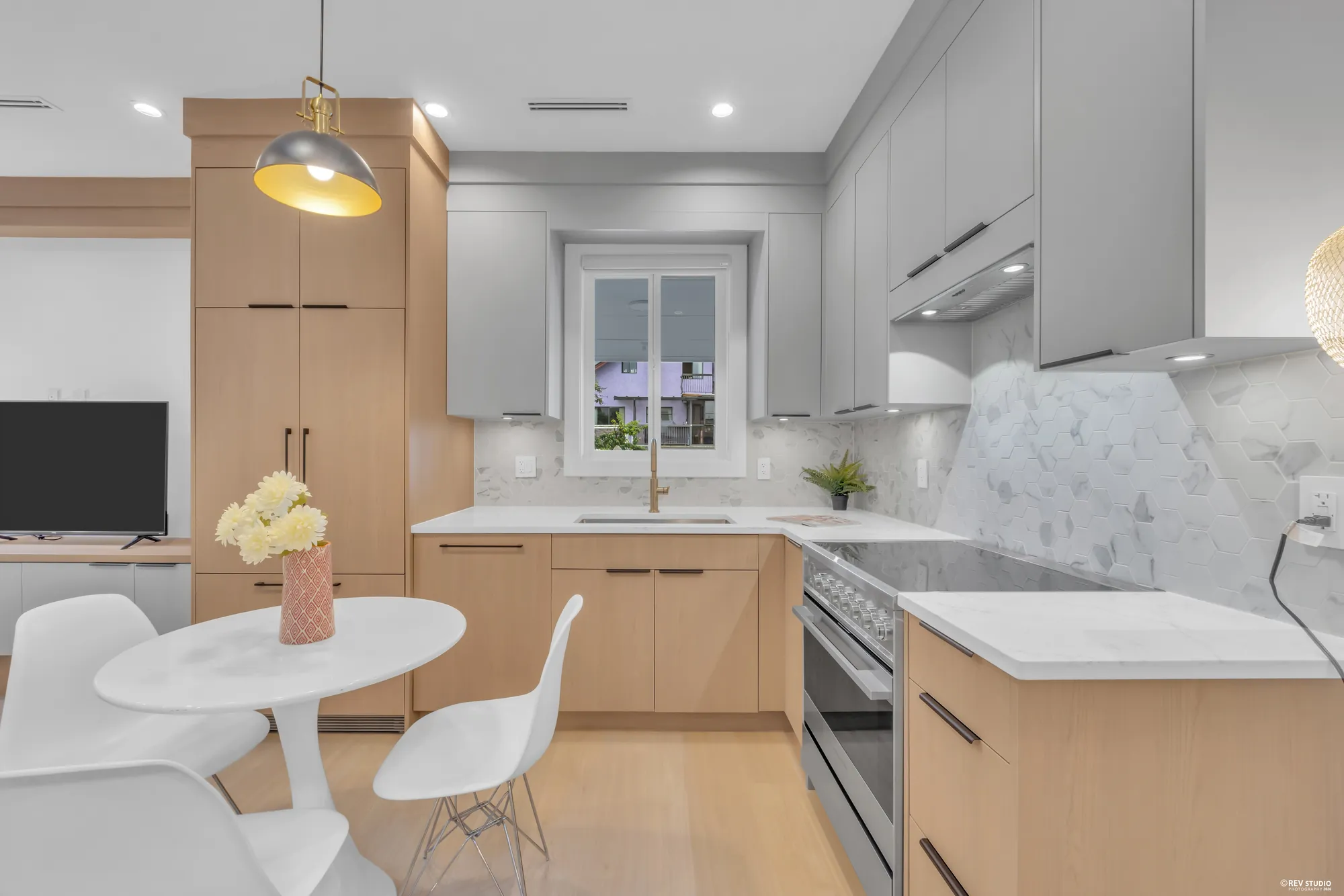 Kitchen counter and range with a pendant light and a marbled stone backsplash