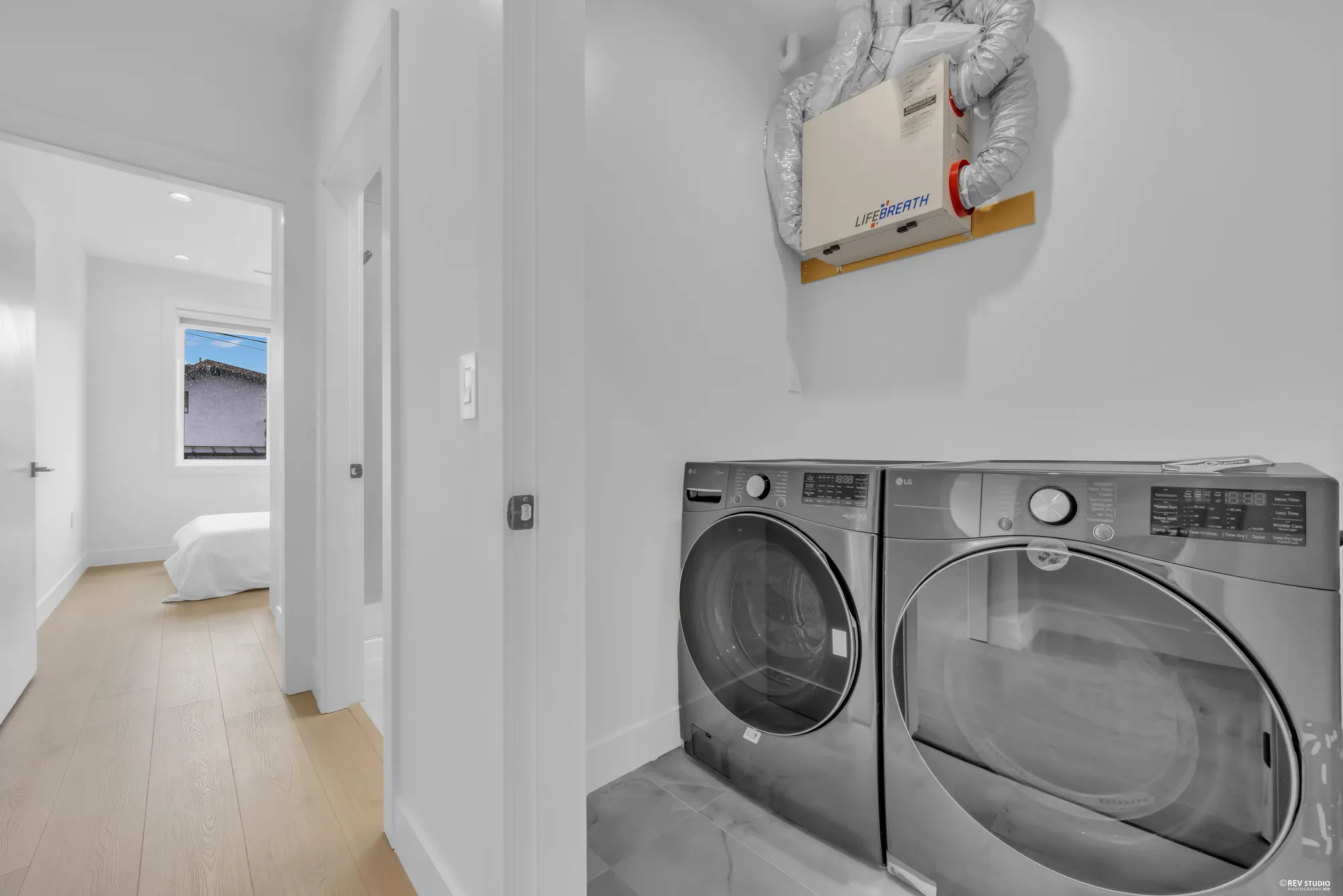 Washer and dryer side by side in a cupboard on the bedroom floor